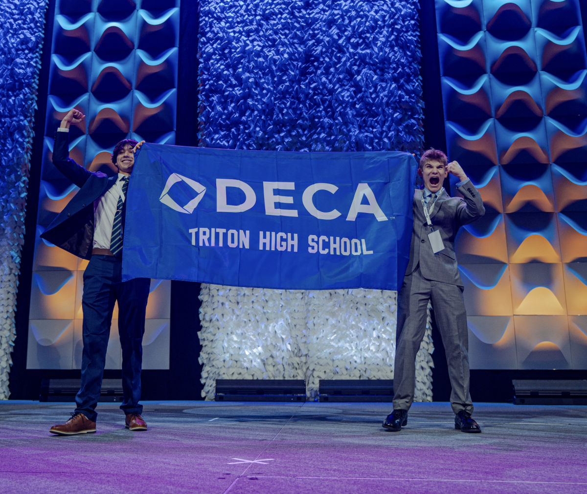 From left: Tim Clark and Tyler Brosh walk across the stage representing Triton DECA.